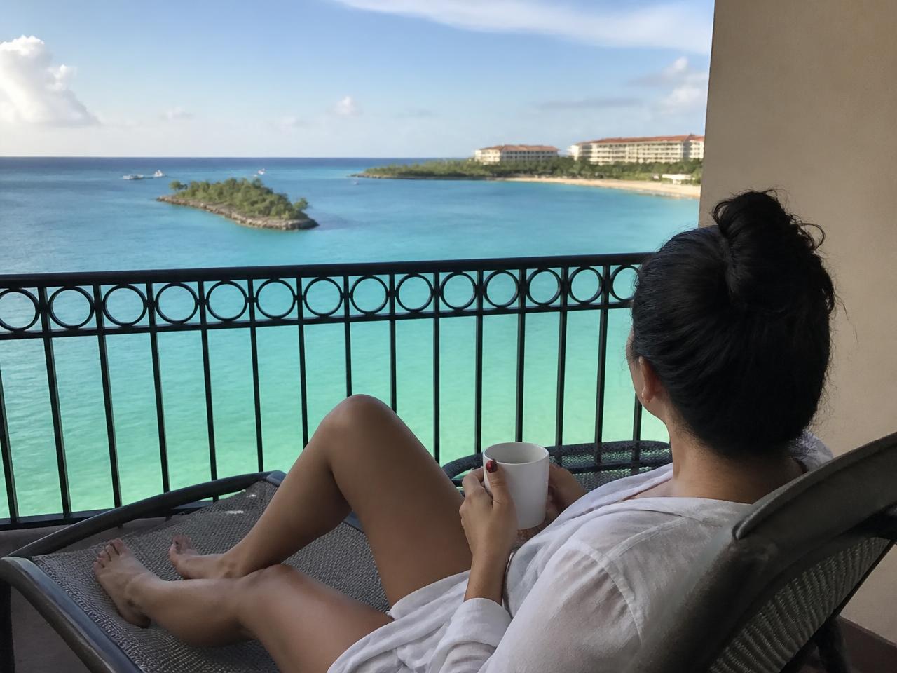 Illustration of a traveler relaxing on a balcony by the ocean